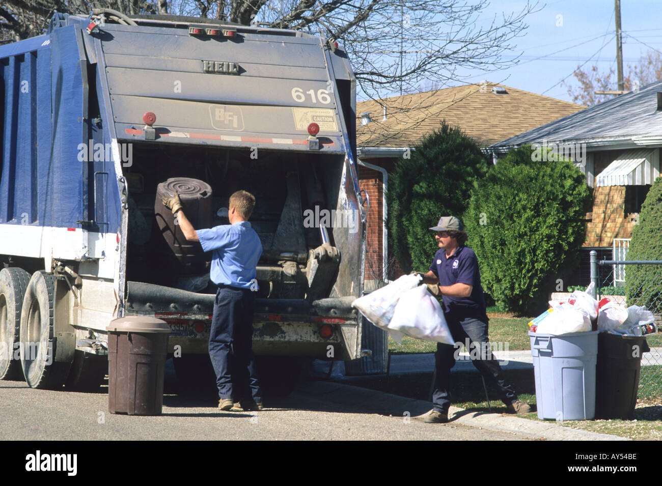 Garbage collectors haul trash from garbage cans Stock Photo Alamy
