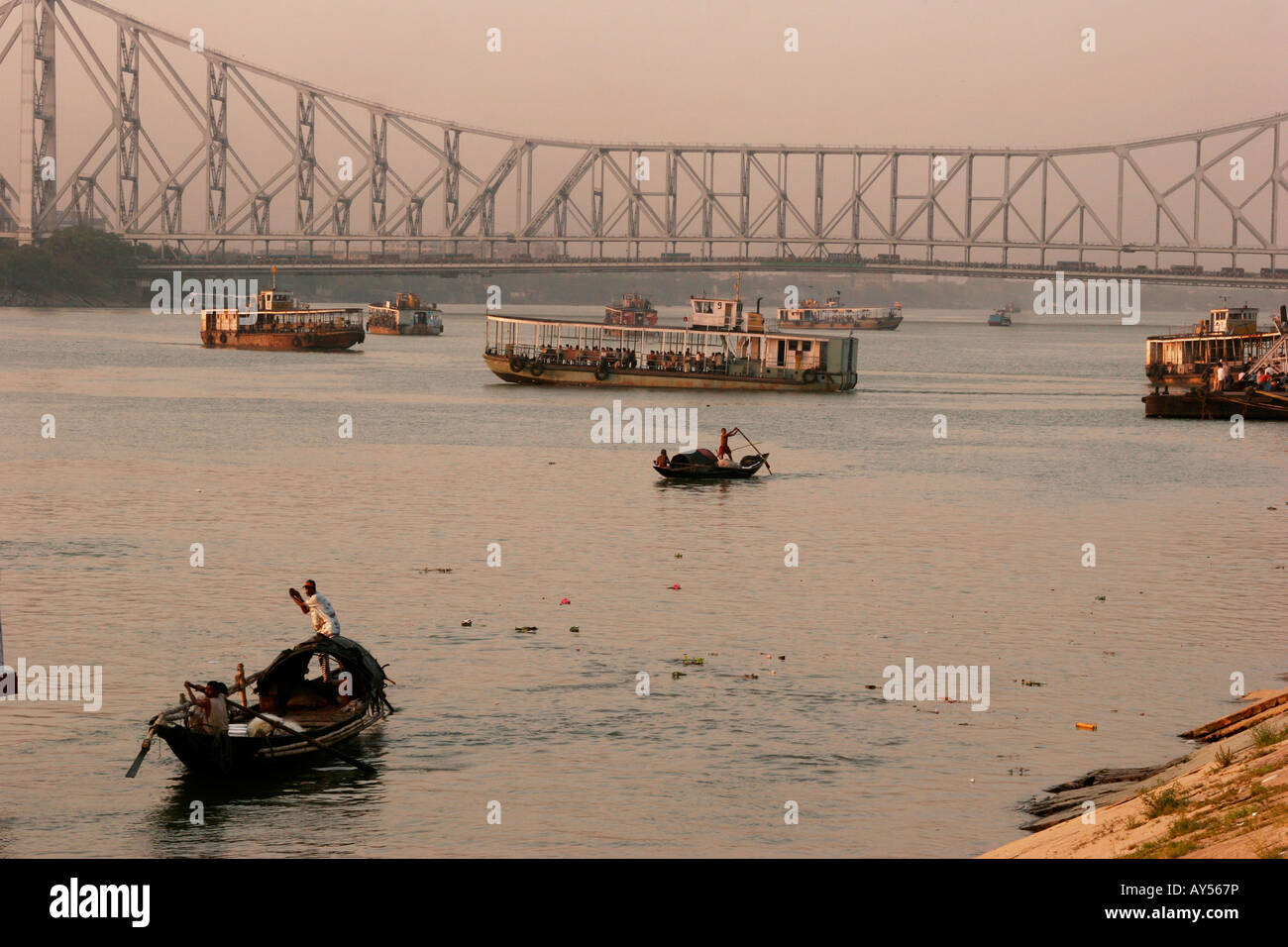 boats on hooghly river and the Howrah Bridge in Kolkata India Stock Photo