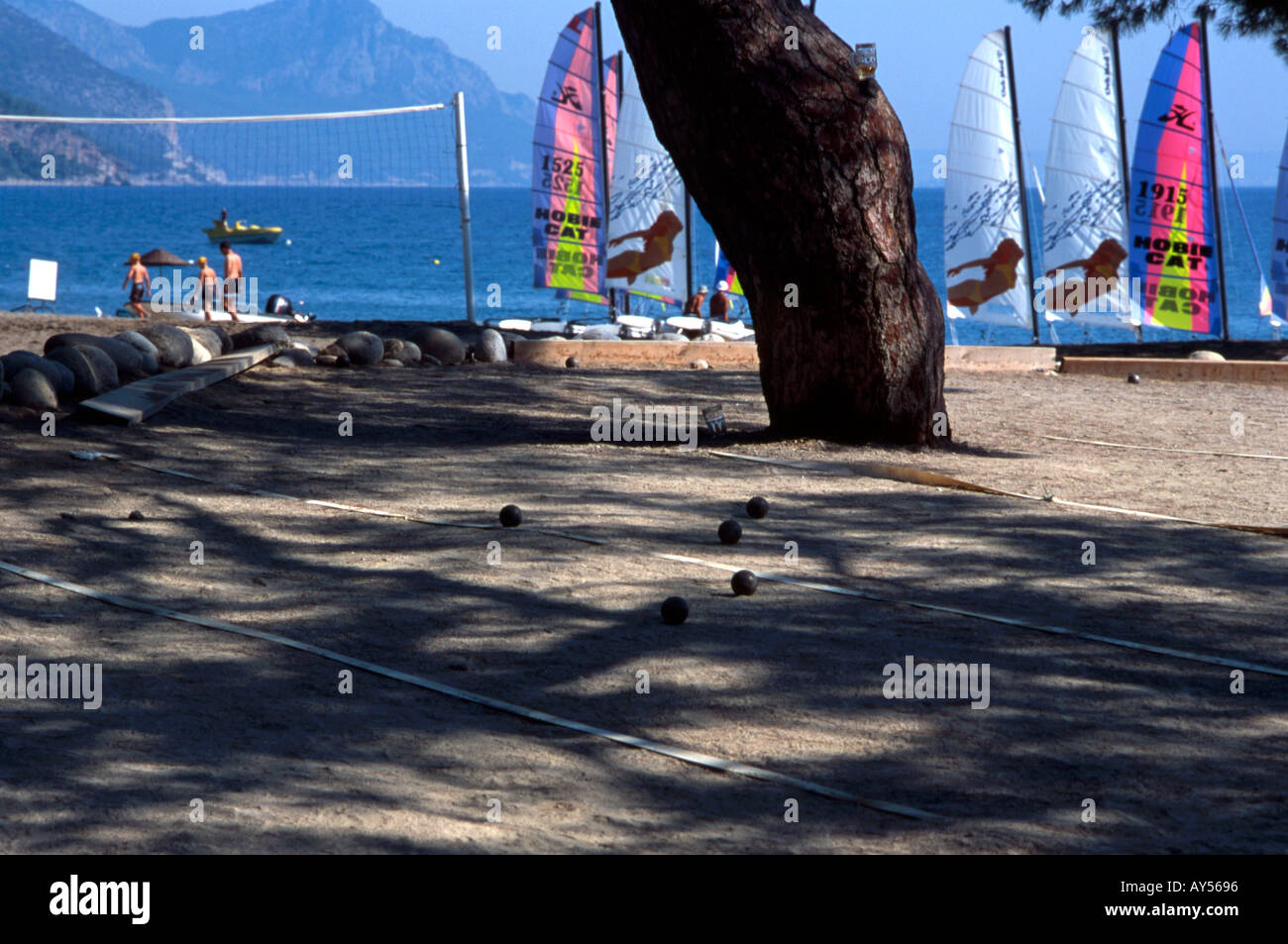 Mediterranean beach with boules sailing boats volleyball net Stock Photo