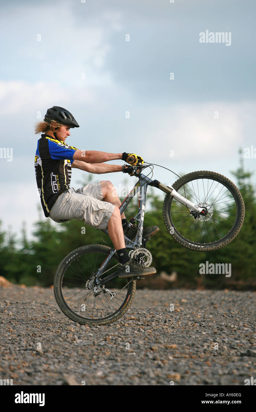 A mountain biker wheelies his mountain bike Stock Photo Alamy