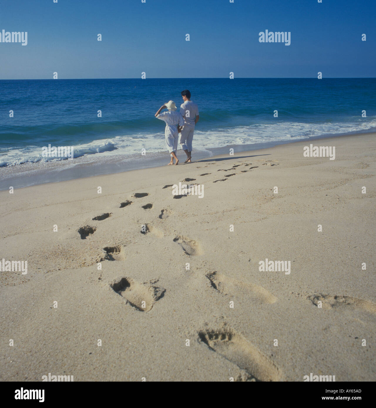 couple leaving footprints in the sand at the beach Stock Photo - Alamy