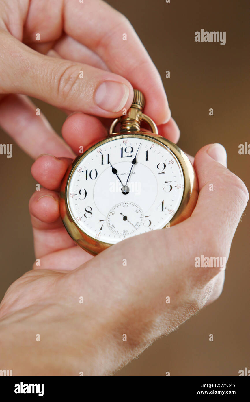 winding or setting a pocket watch Stock Photo Alamy