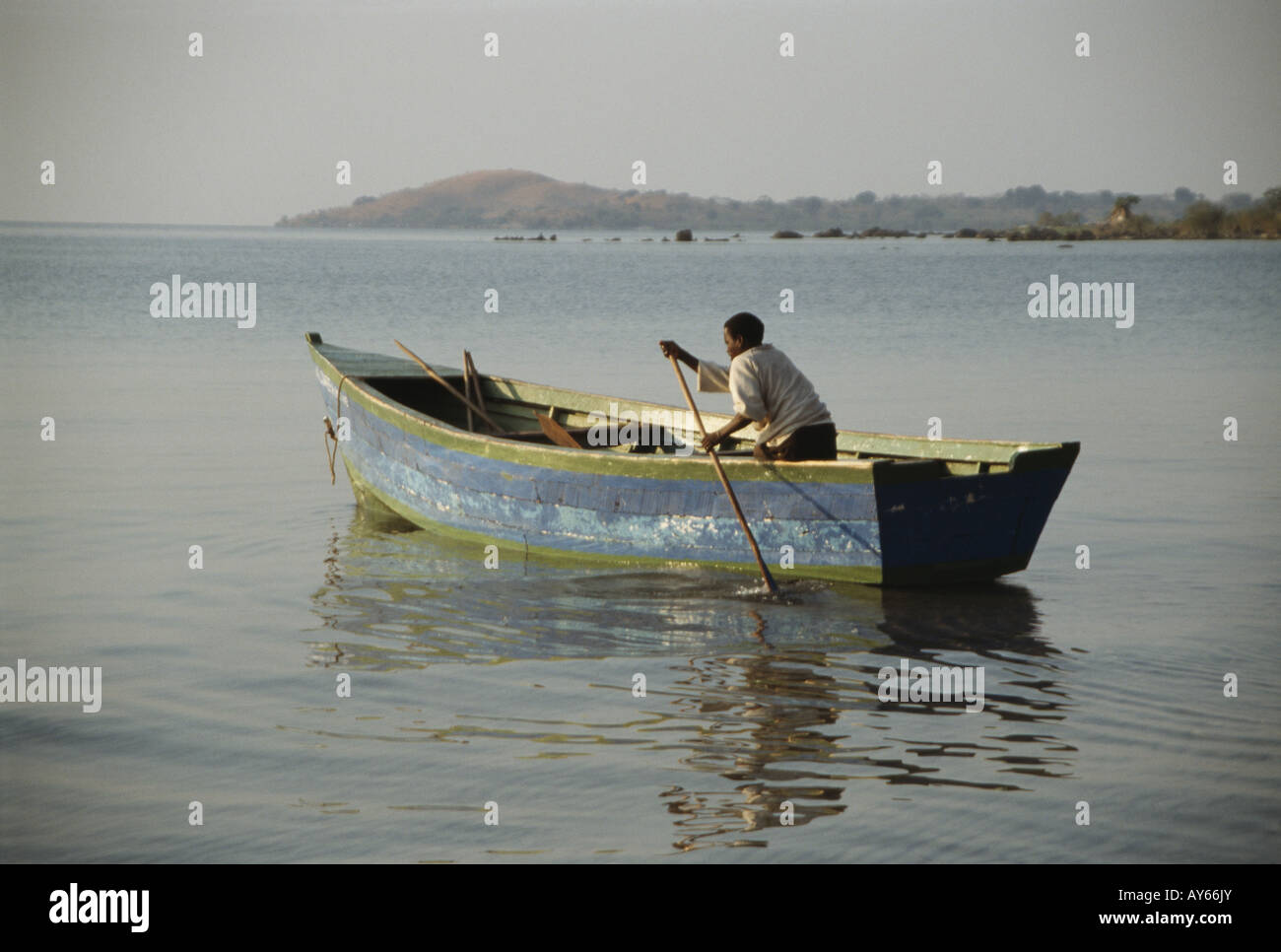 Lake Water Flat calm water Man sitting in small wooden fishing boat