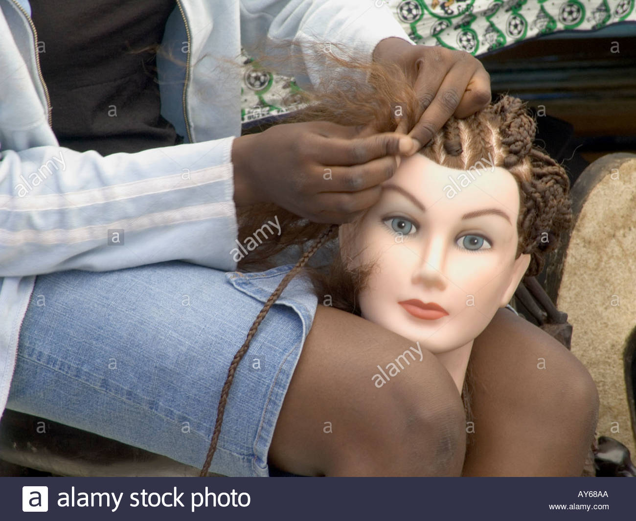 Girl Practicing Braiding Hair On A Mannequins Head Stock Photo