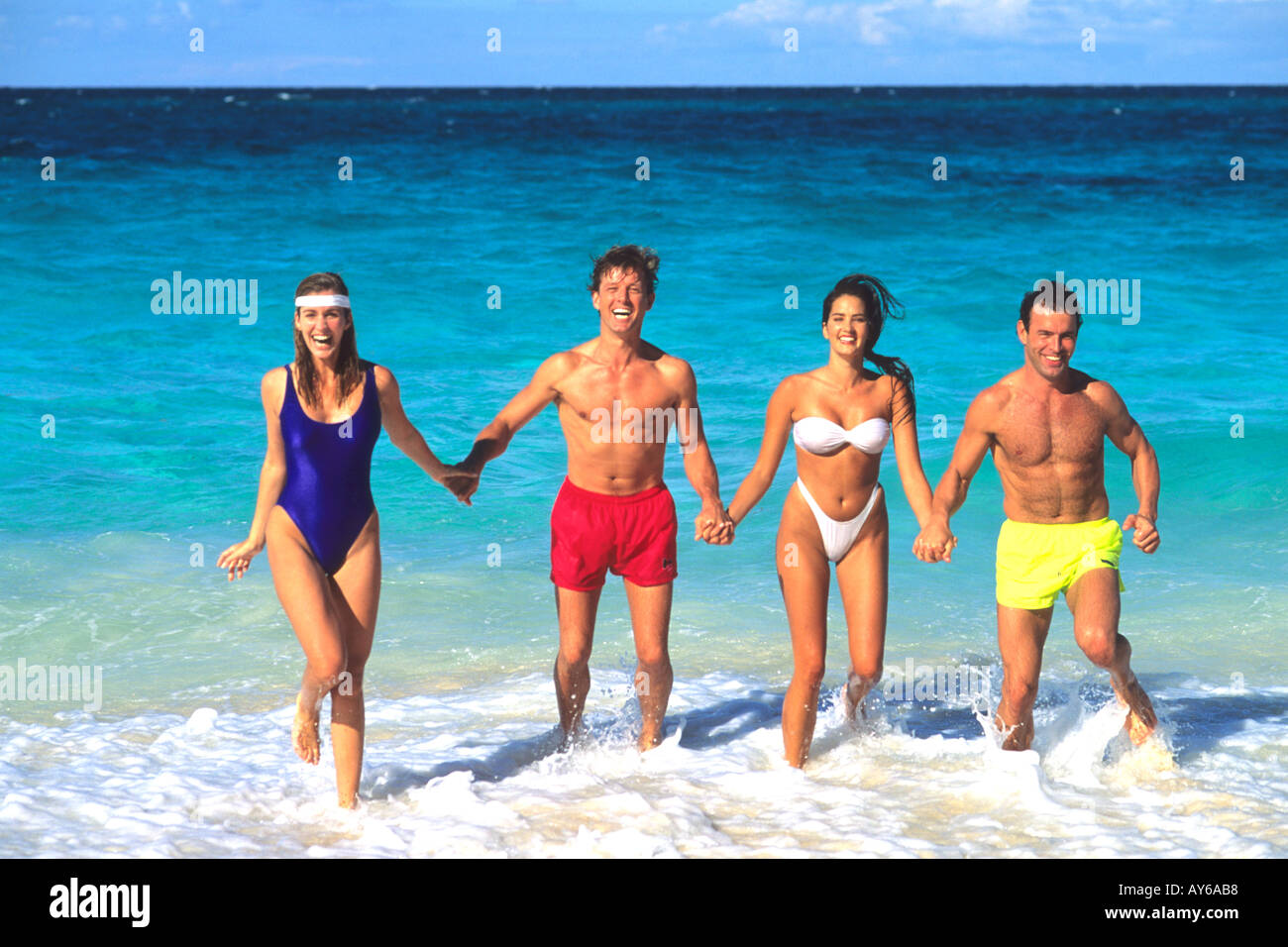 Couples Having Fun in Surf on Caribbean Beach Stock Photo