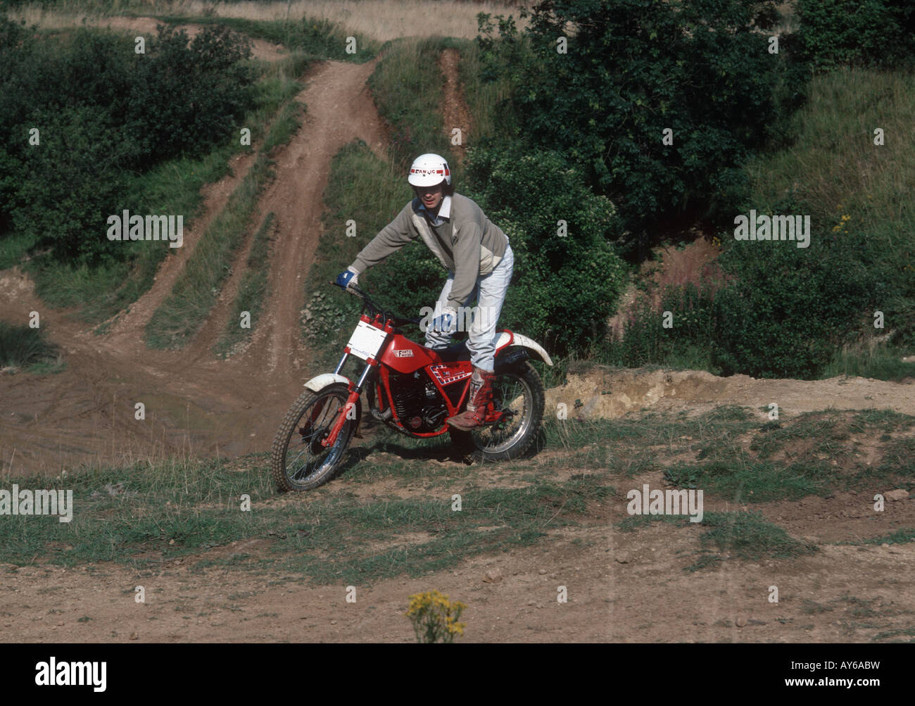 Young motorcyclist on scrambler trial bike on quarry site Cotswold countryside UK Stock Photo