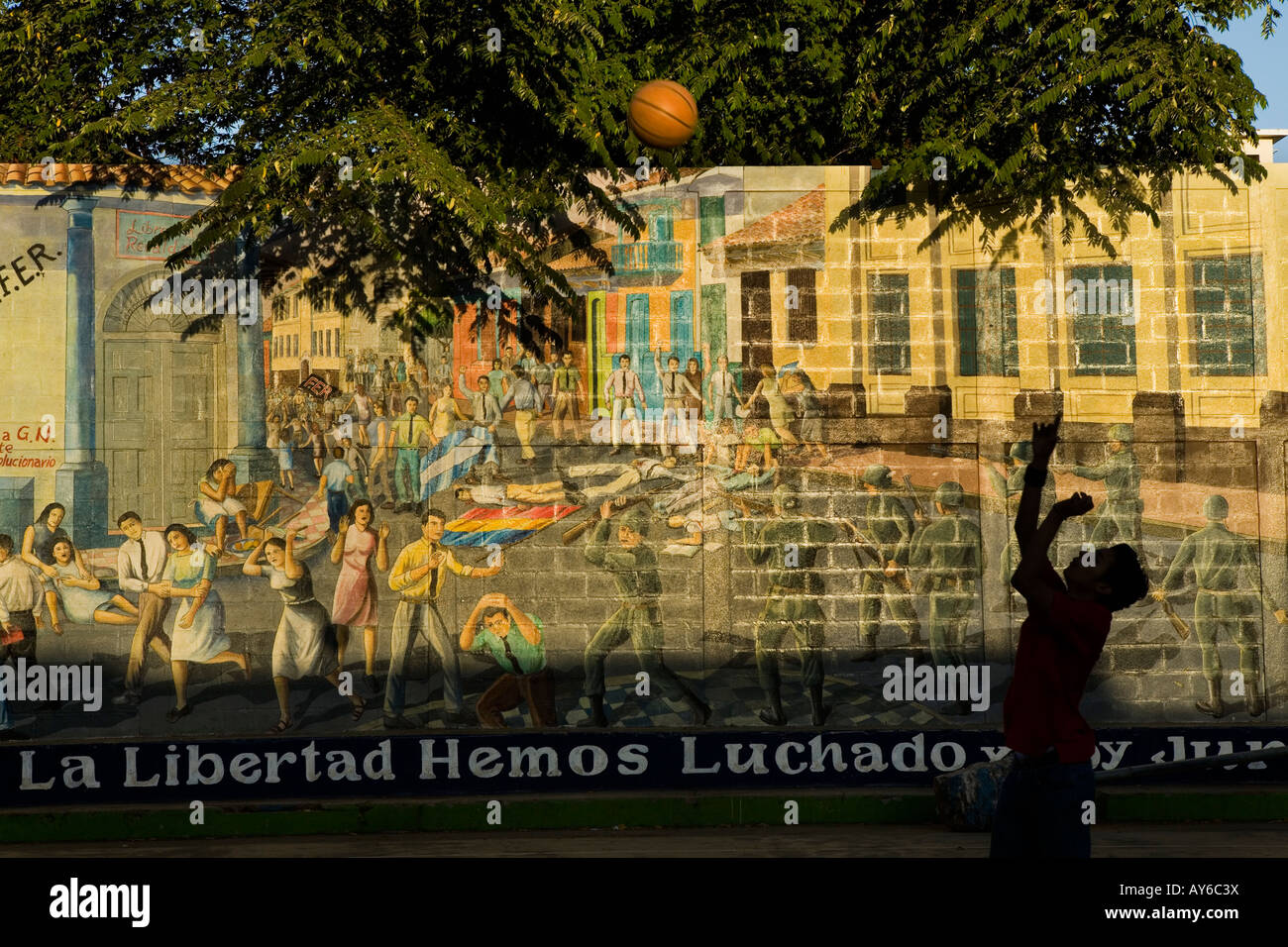 Boy playing basketball by Sandinista mural Leon Nicaragua Stock Photo