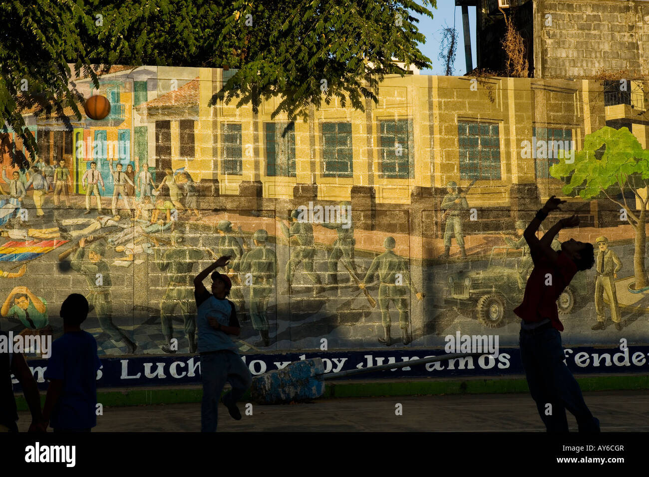 Boys playing basketball by Sandinista mural Leon Nicaragua Stock Photo