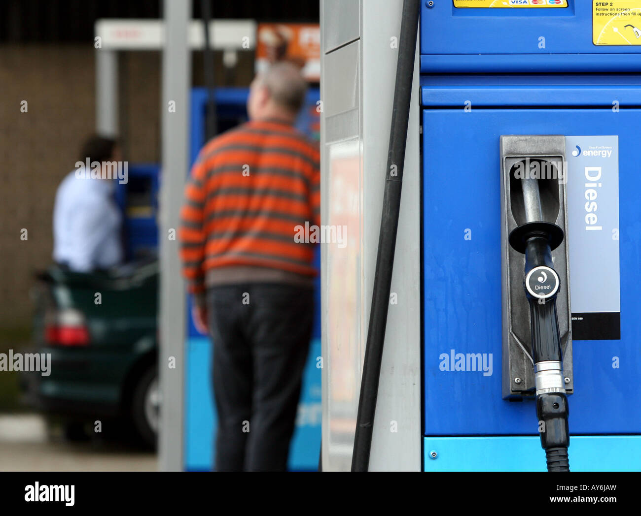 Two men fill up their cars at an Esso petrol service station in Essex Stock Photo