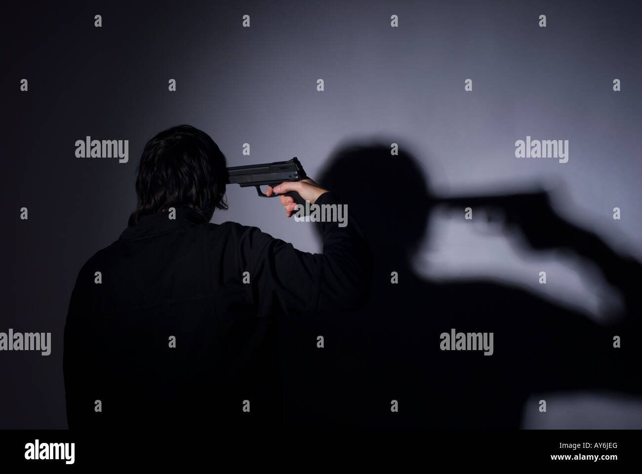 A studio shot of a young male with a gun Stock Photo