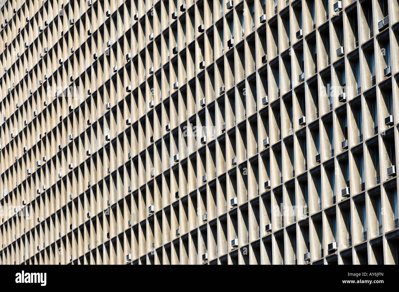 Air conditioners protrude from windows in large apartment building in