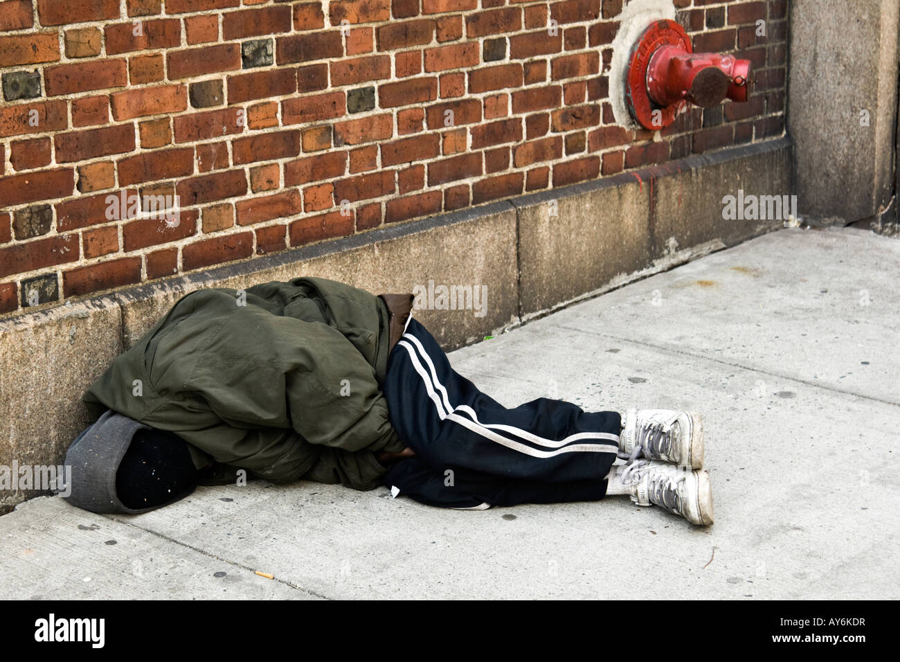 Homeless man tries to keep warm while sleeping on a New York city