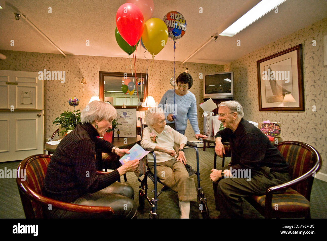 Family and friends congratulate a centenarian after her 100th birthday party at a nursing home in Stoneham MA Stock Photo