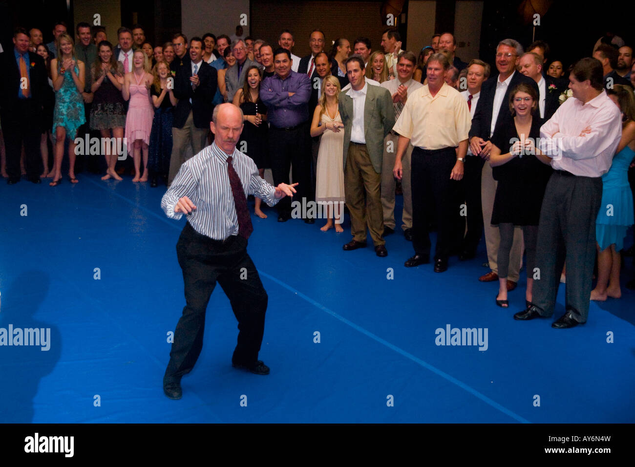As teen girls and their their fathers watch a father competes in a Dads Only dance contest at a Dance With the Dads event Stock Photo