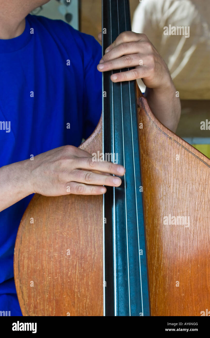 Close up of cello and hands plucking strings; pizzicato method of playing by plucking strings with fingers rather than using bow Stock Photo