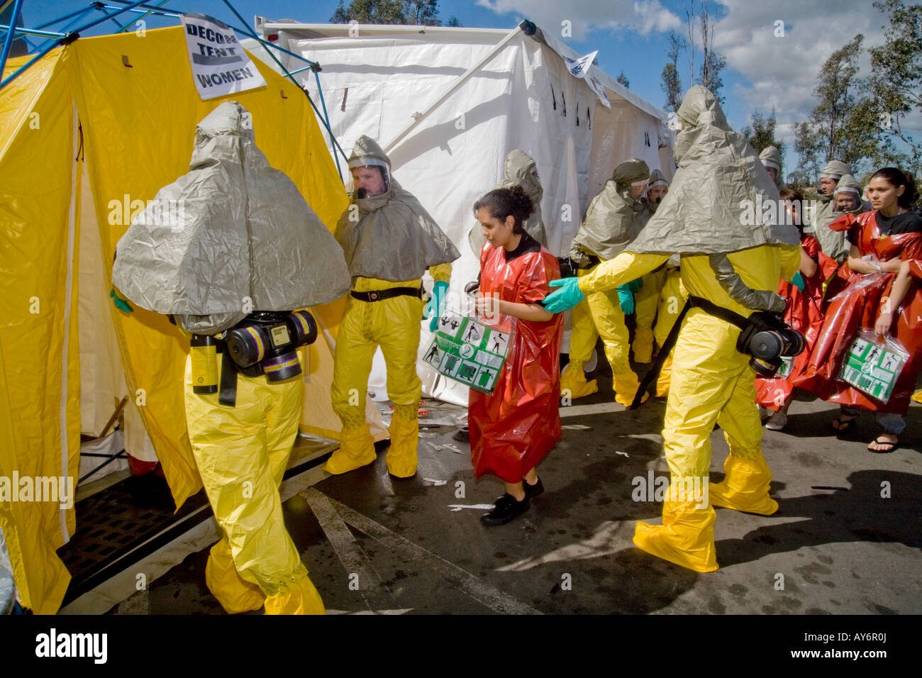In chemical bioligical protective clothing personnel direct volunteer  victims in disposable emergency outfits to decontamination Stock Photo -  Alamy