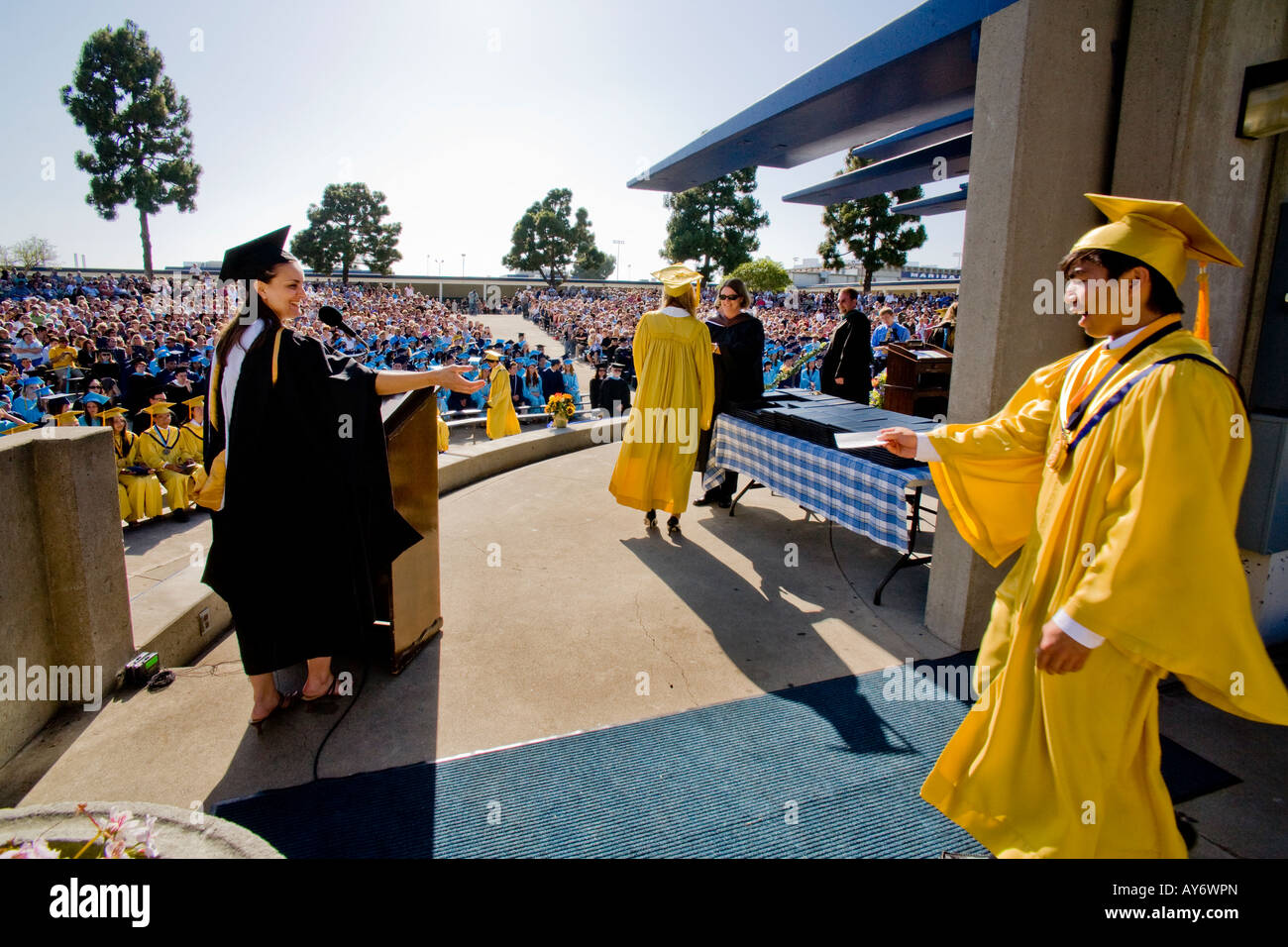 Hispanic senior gives his name as he steps out to receive high school diploma Stock Photo