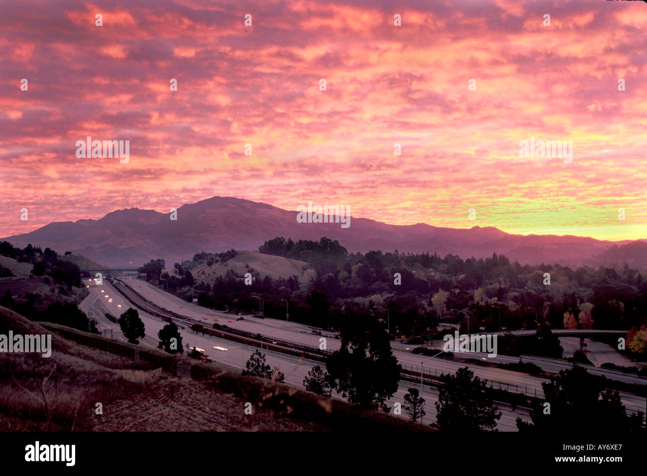 fiirery red sunrise over purple mountain near freeway in Lafayette California Stock Photo
