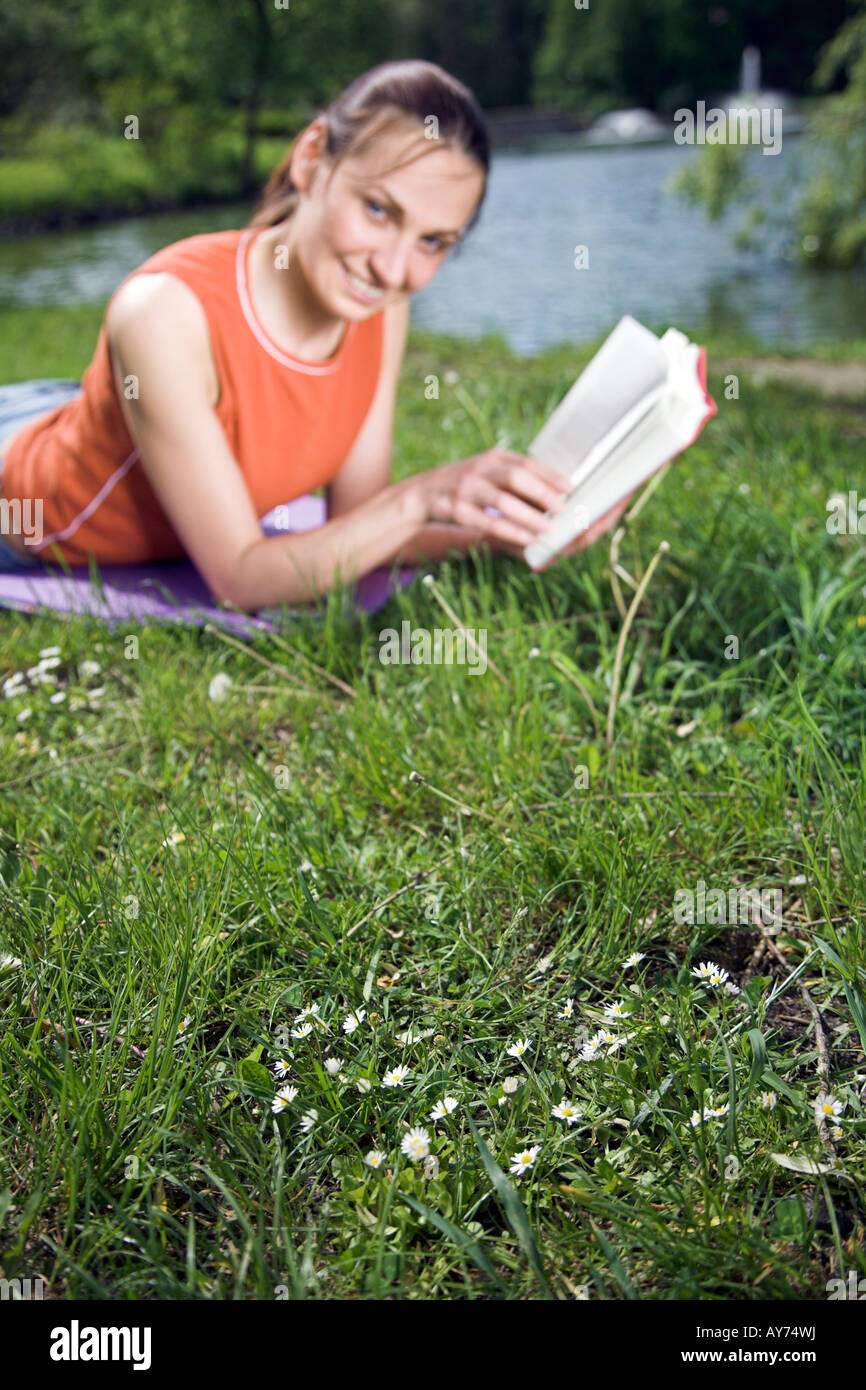Woman sitting in a park and reading a book Stock Photo - Alamy