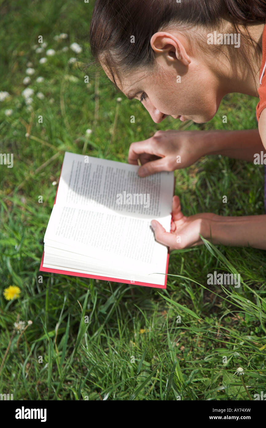 Woman sitting in a park and reading a book Stock Photo - Alamy
