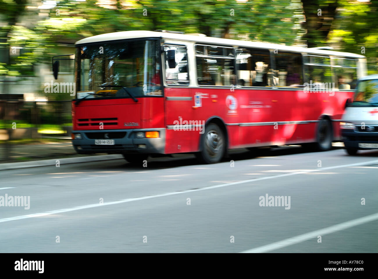 Bus Driving on a Busy City Street Stock Photo