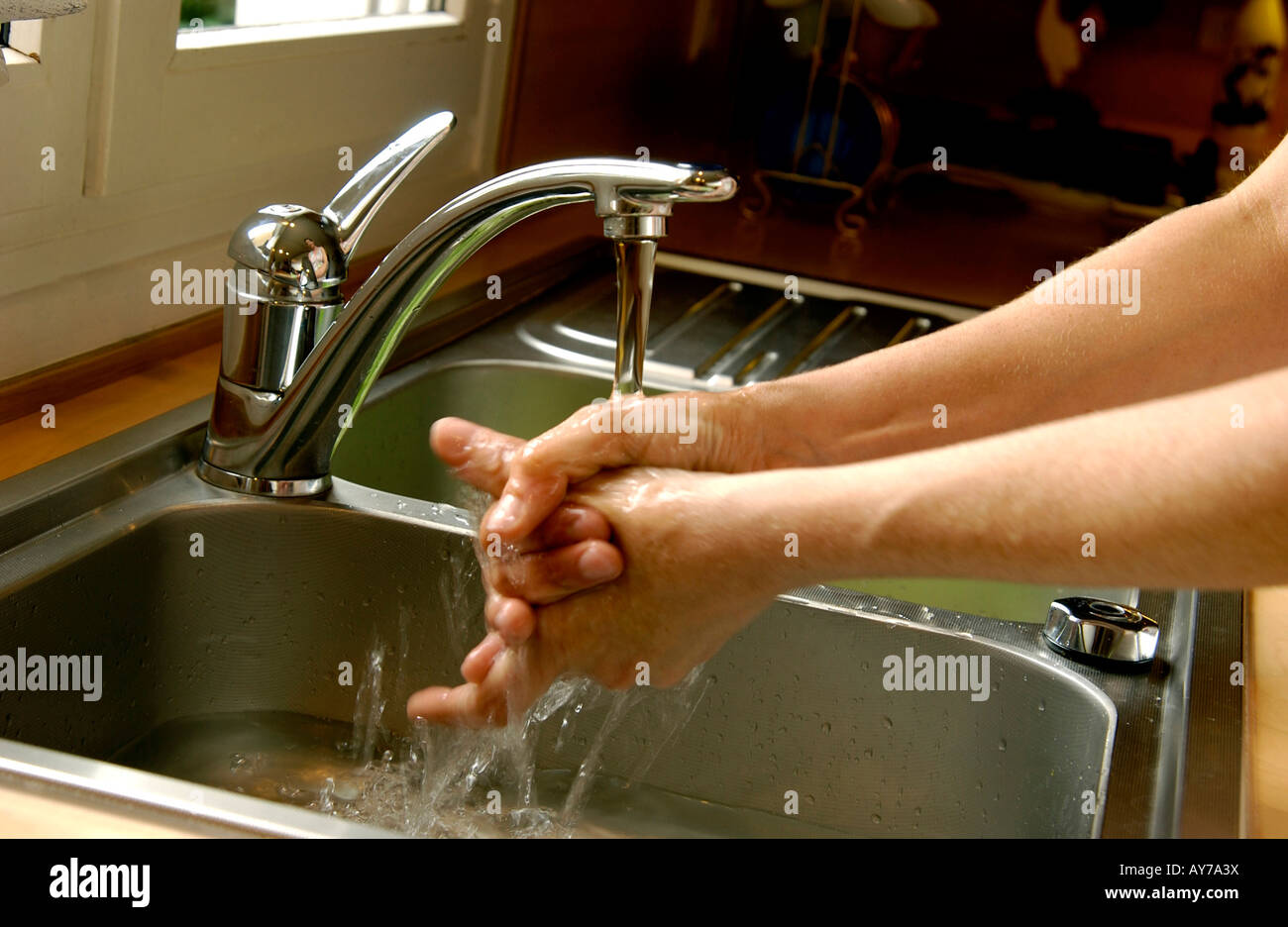 Washing hands in the kitchen sink Stock Photo Alamy