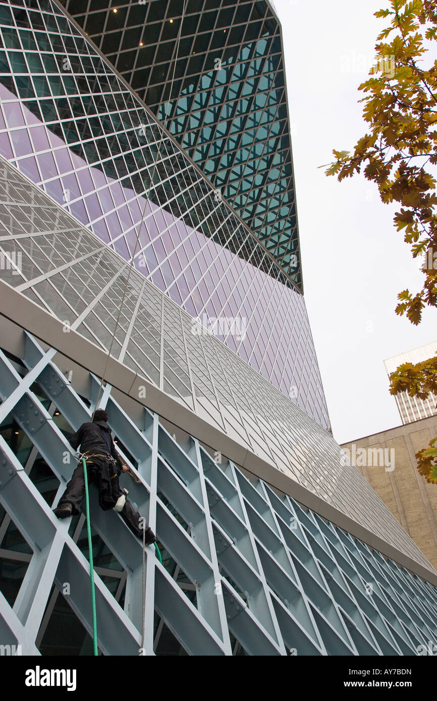 Cleaning at all Angles A window washer works on cleaning the complex steel beam diamond exterior of this 2004 Seattle building Stock Photo