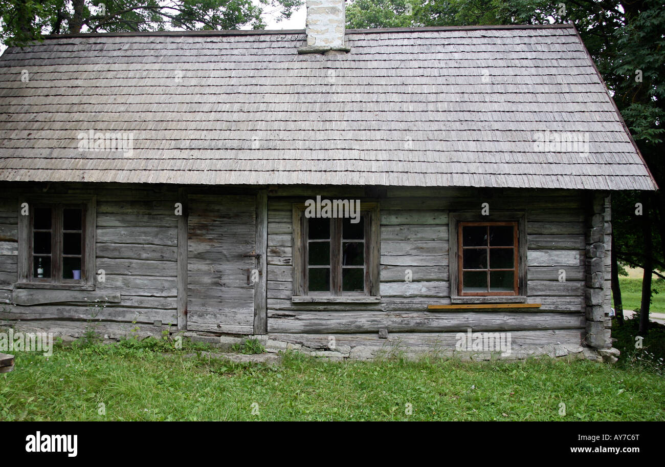 Rustic old wood house or cottage, unpainted, grey walls and roof. Grass
