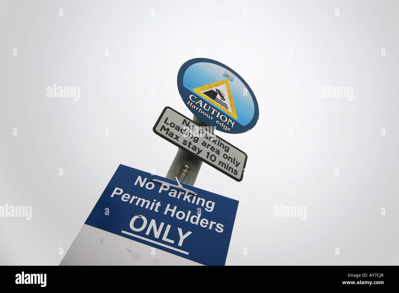 Sign stating no parking except for permit holders and danger of driving off a pier into deep