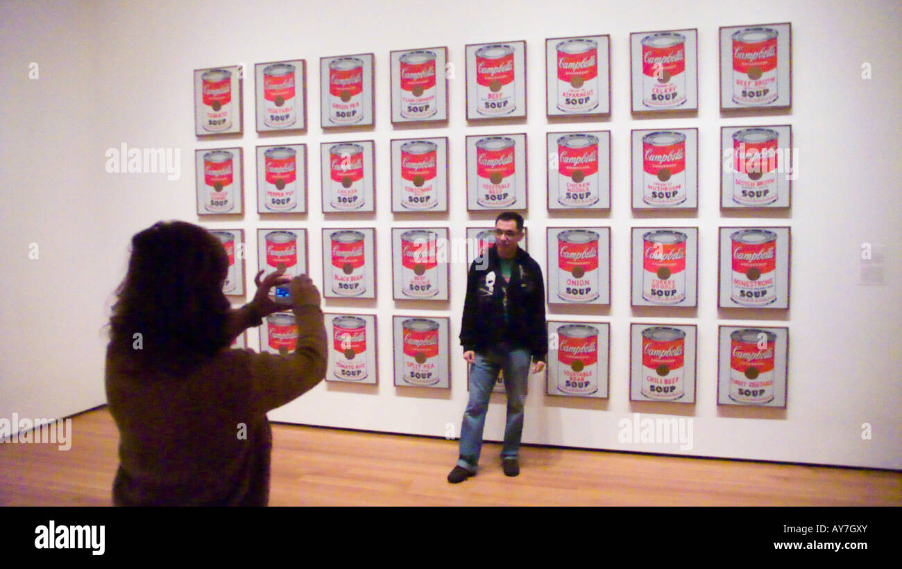 Man posing to woman in front of Andy Warhol s Campbell s Soup Cans The Museum of Modern Art MoMA New York USA Stock Photo