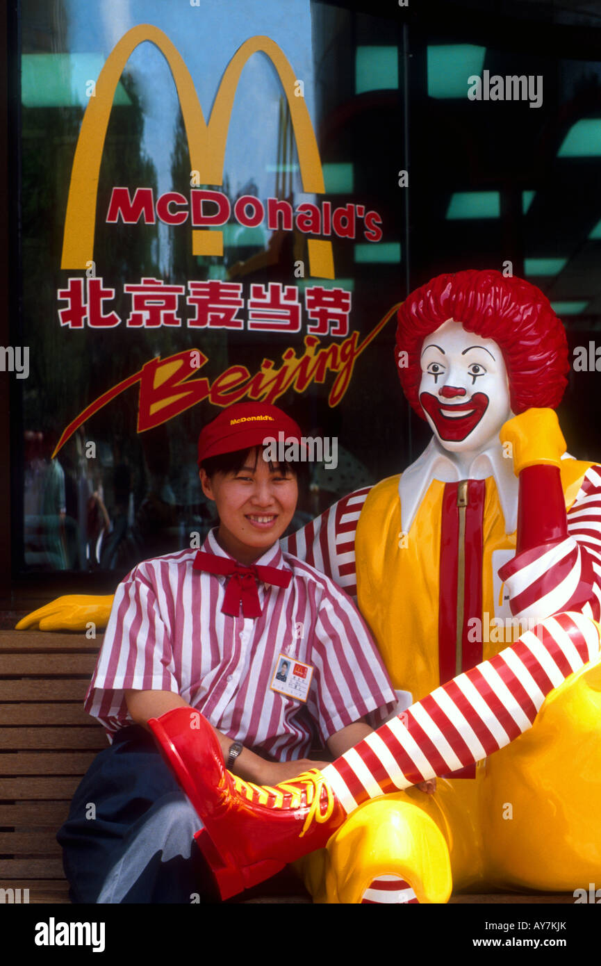 Beijing McDonalds employee with Ronald McDonald statue on bench at entrance Stock Photo