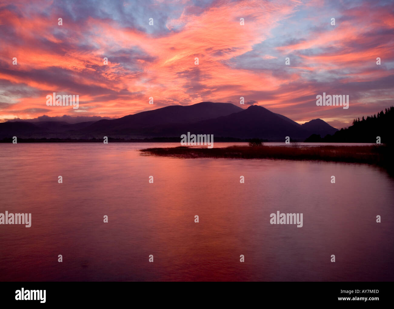 Sunrise over Bassenthwaite, Lake District, Cumbria with Skiddaw, Ullock Pike and Dodd silhouetted in the background. Stock Photo