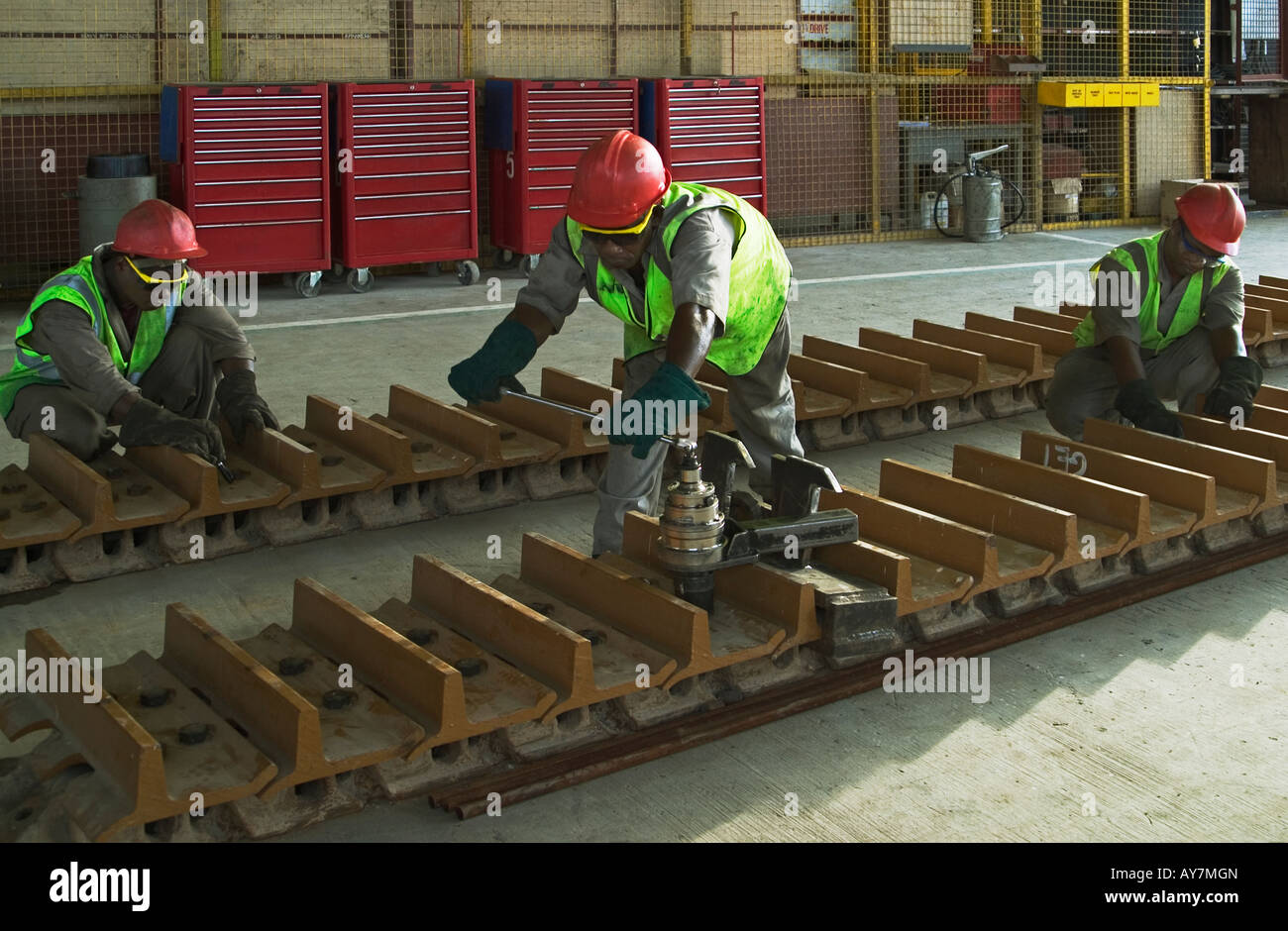 Repairing track of Caterpillar bulldozer mining vehicle in maintenance workshop, Ghana, West Africa Stock Photo