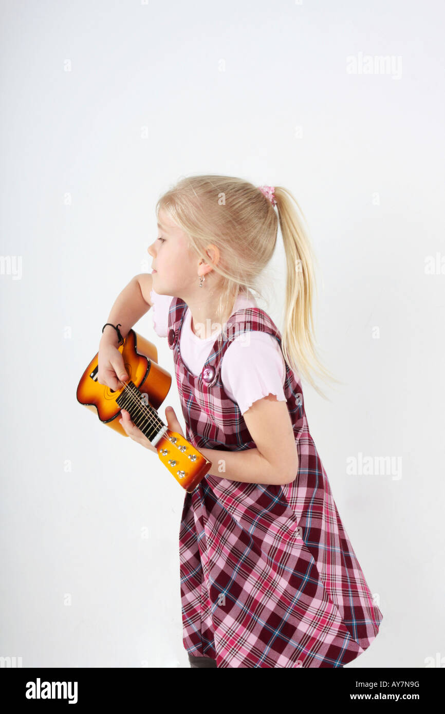 small girl playing a toy guitar Stock Photo