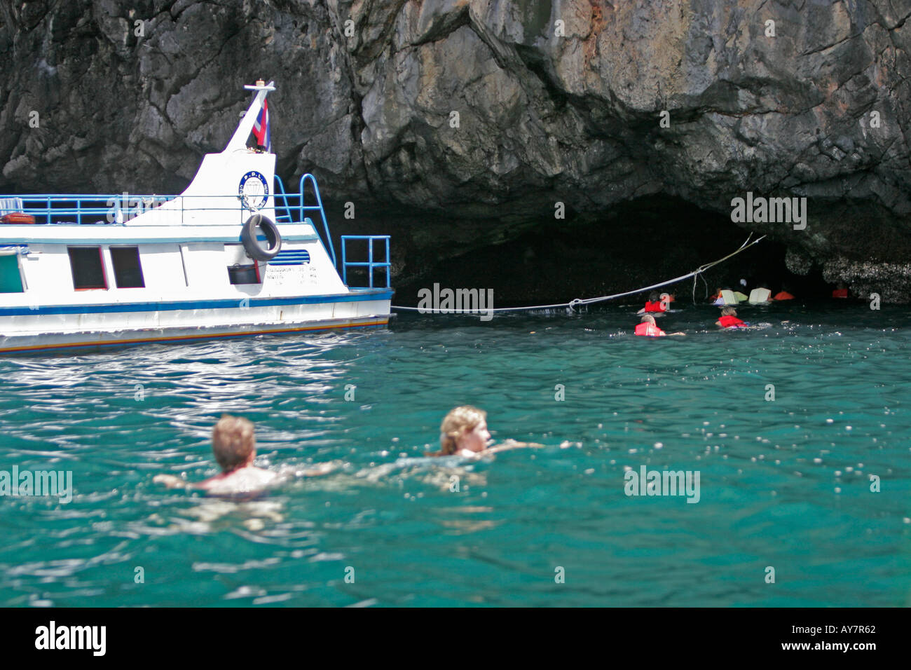 Visitors with life jackets paddle into the Emerald Cave Ko Muk island Thailand Stock Photo