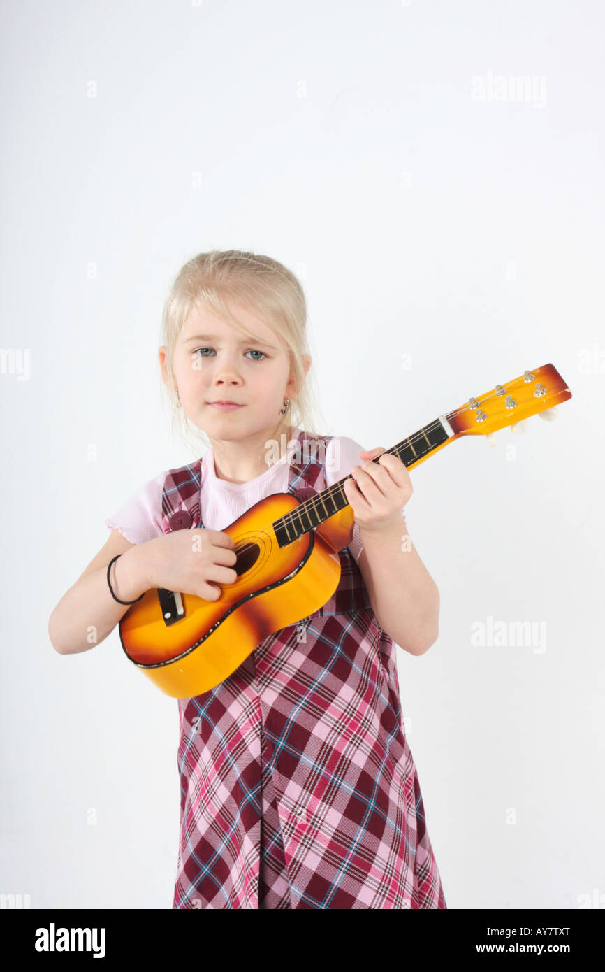 small girl playing a toy guitar Stock Photo