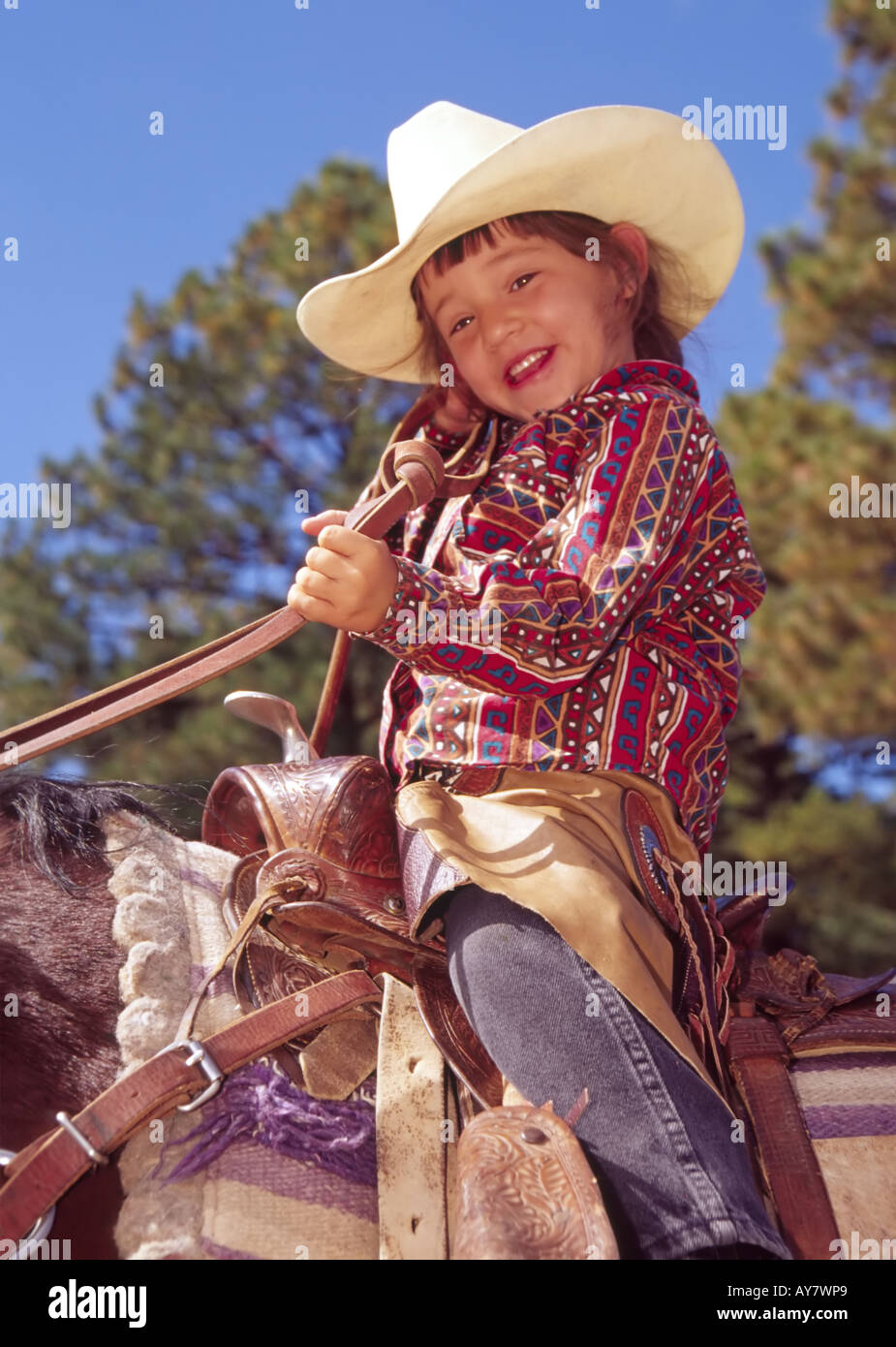 A smiling young cowgirl rides her horse in the Aspenfest Parade, in ...