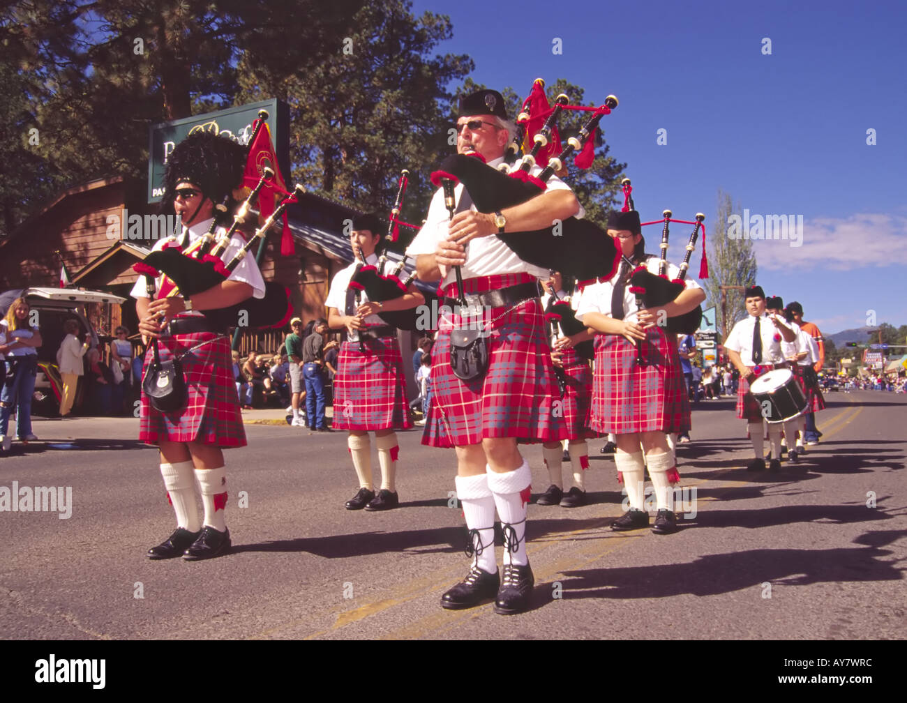 Men in red tartan kilts play bagpipes at the Aspenfest Parade, in downtown Ruidoso, New  Mexico. Stock Photo