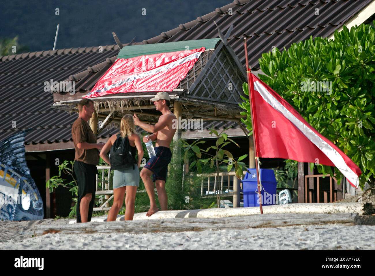 Young couple discuss diving with instructor at dive shop Pattaya Beach Ko Lipe island Thailand Stock Photo