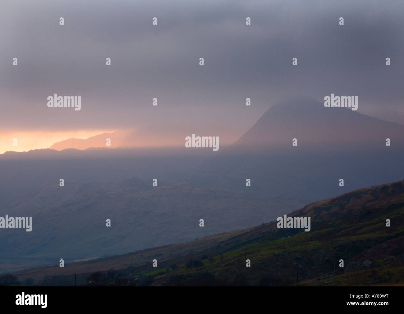 Sunlight bursting through the clouds over Mt Snowdon at sunset Snowdonia Wales UK Stock Photo