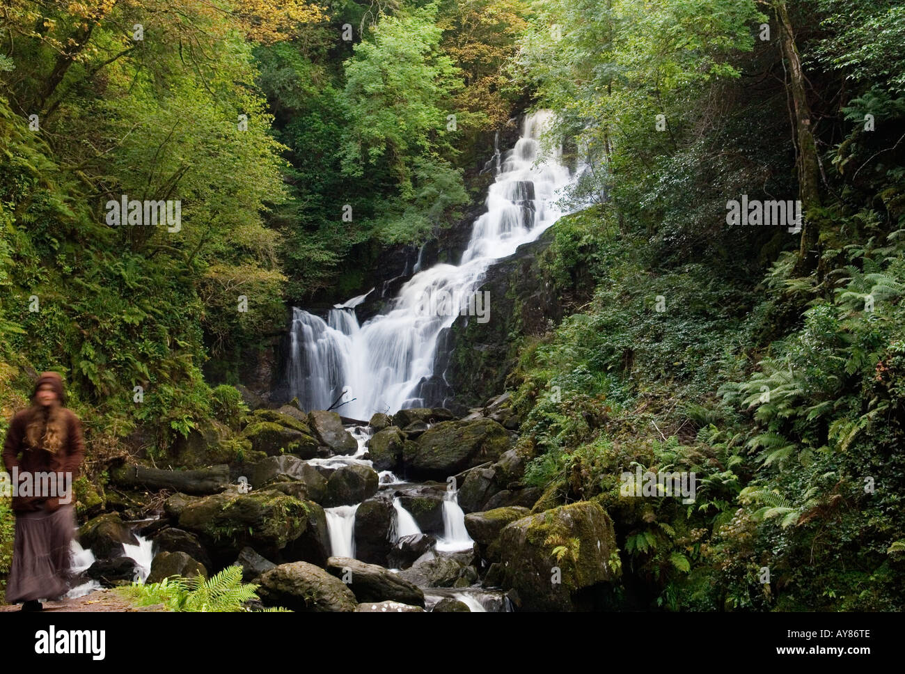 Torc Waterfall on the Owengarrif River beside Muckross Lake, Killarney, Ireland. Ghostly cloaked figure of young woman on left. Stock Photo