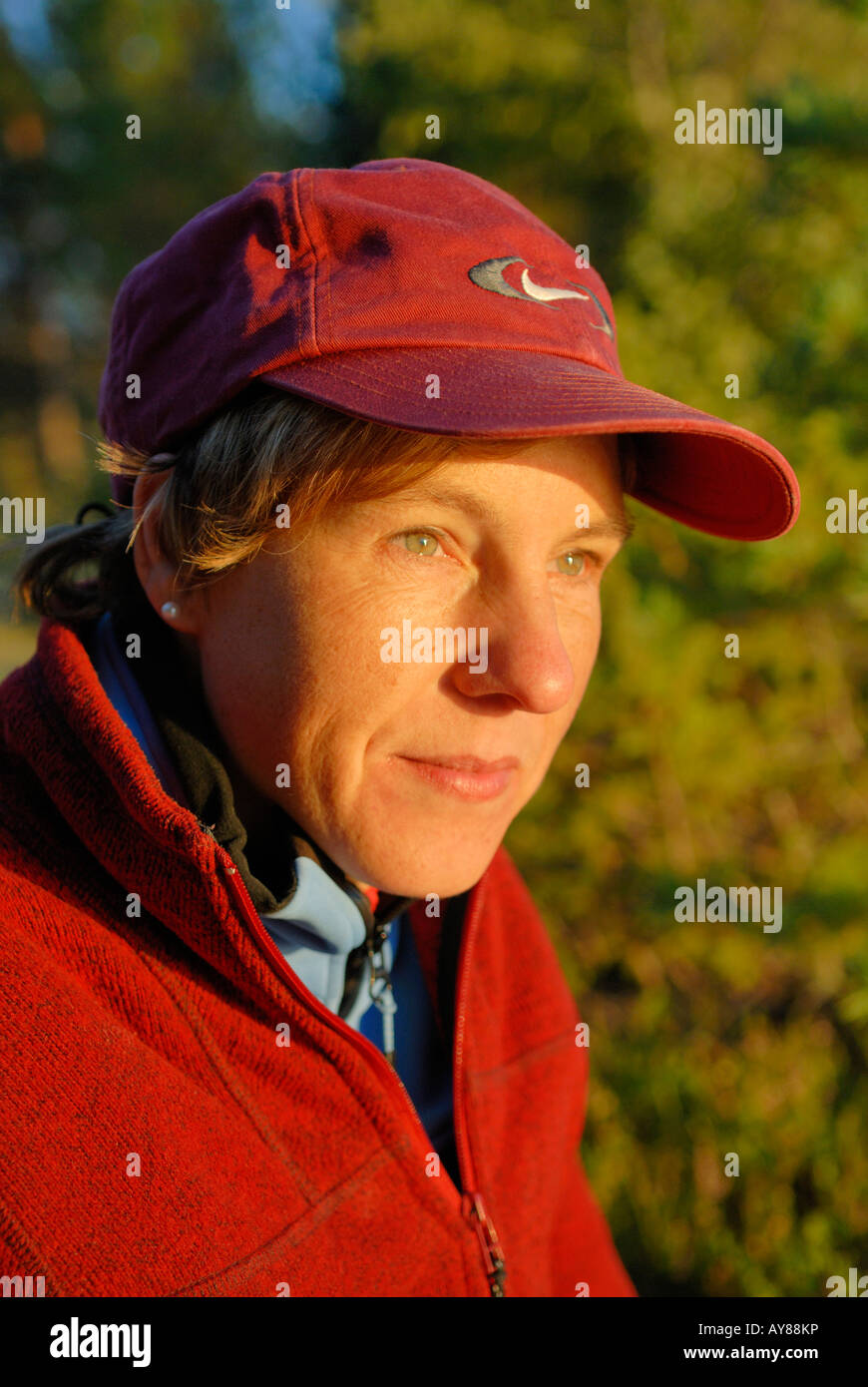 A middle aged woman with a red cap and red jacket looking in the evening sun Harjedalen, Sweden Augst 2007 Stock Photo