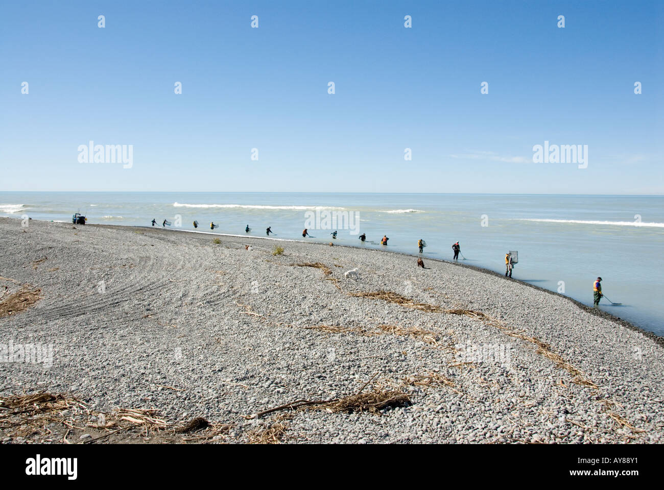 Whitebaiters line the beach at the mouth of the Rakaia river New Zealand Stock Photo