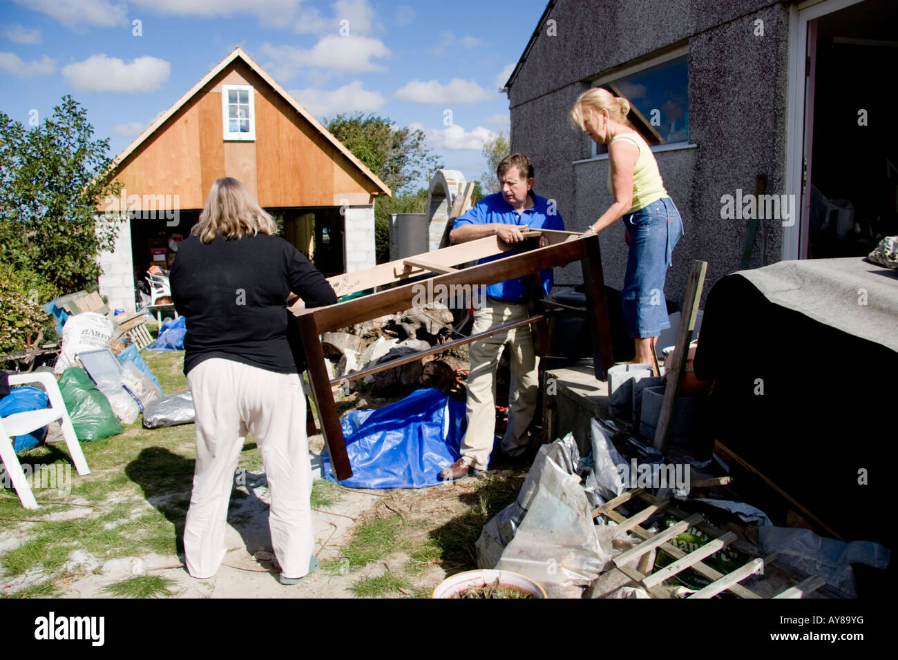 Mature man and women carrying furniture from a house Stock Photo