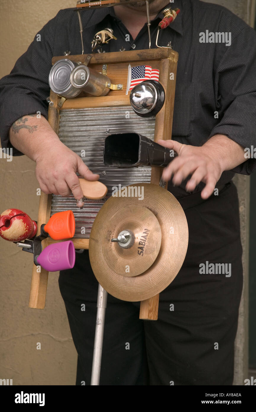 Detail view of mans hands playing washboard with cymbals and bells