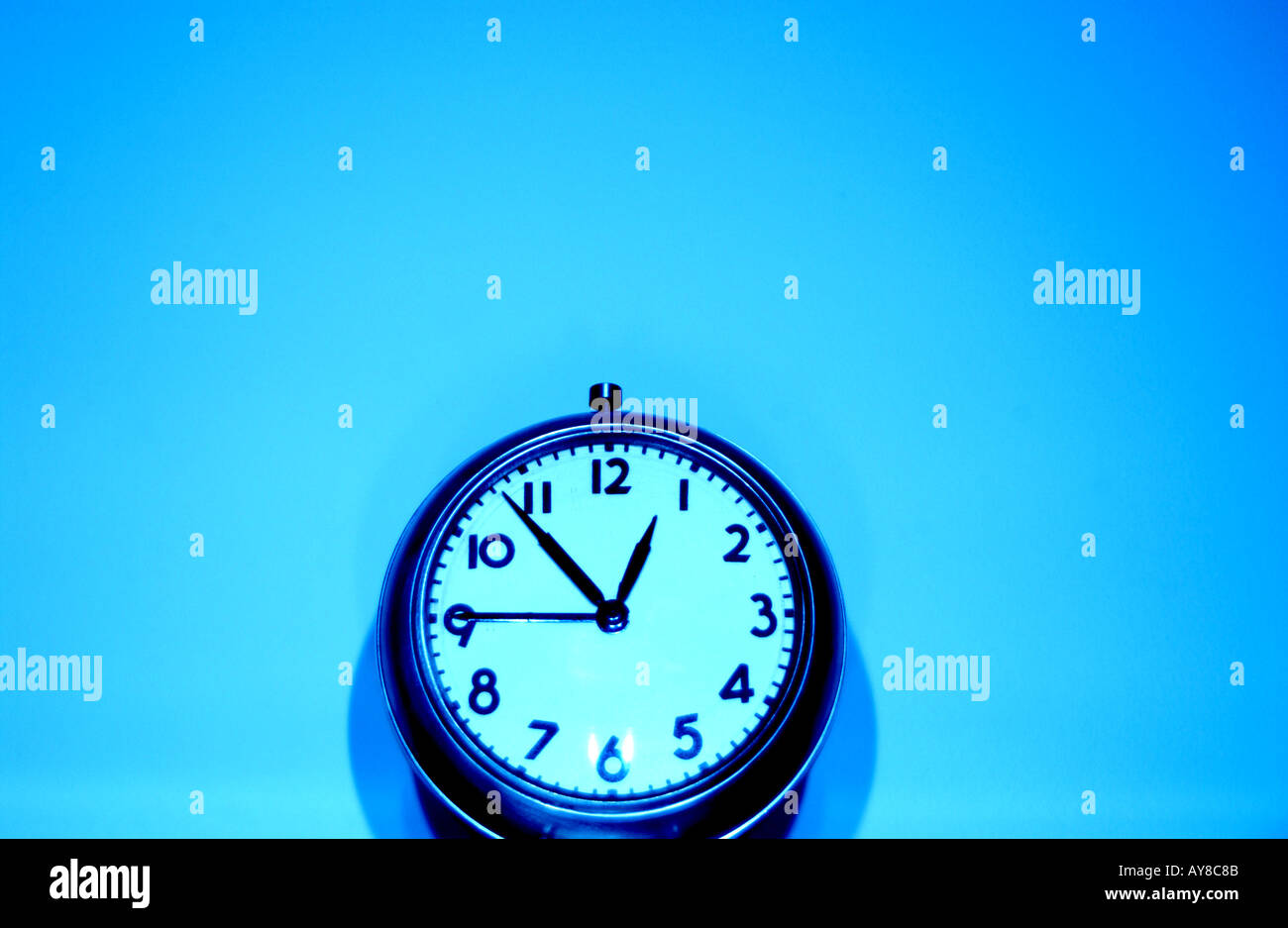 Horizontal abstract color image of clock sitting against a plain wall ...