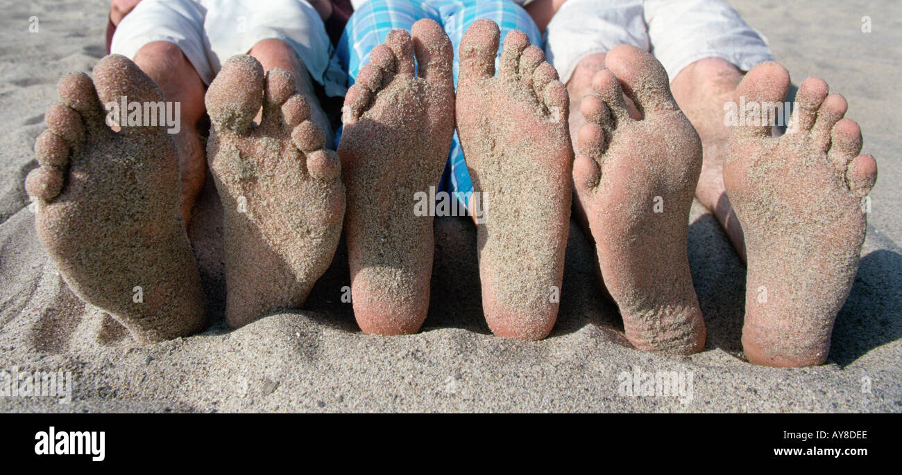 Teenagers relax on Southern California beach with sandy feet Stock