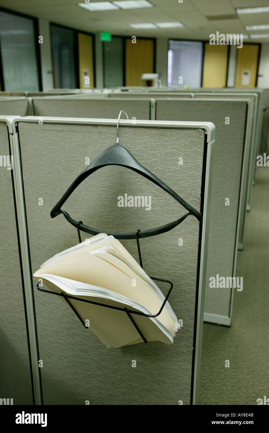 Hanger holds paperwork for employee at small cubicle in highrise office building Stock Photo