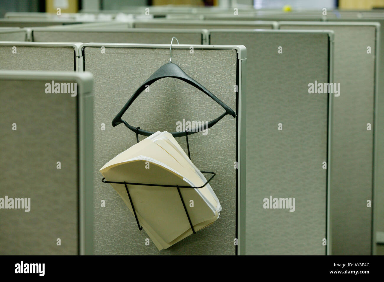 Hanger holds paperwork for employee at small cubicle in highrise office building Stock Photo