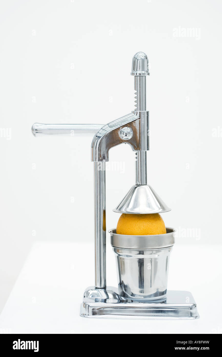 Orange in citrus press, closeup Stock Photo Alamy